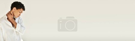 Téléchargez les photos : Homme afro-américain raffiné dans des vêtements en lin chic regardant loin sur fond beige, bannière - en image libre de droit