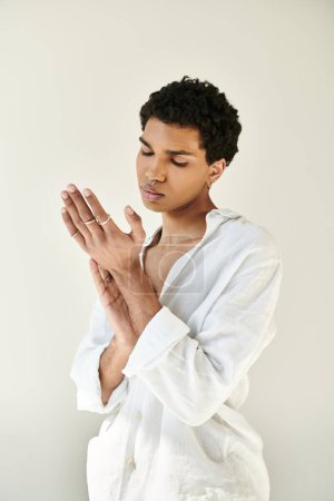 Foto de Hombre afroamericano elegante de buen aspecto en ropa de lino elegante mirando hacia otro lado en fondo beige - Imagen libre de derechos