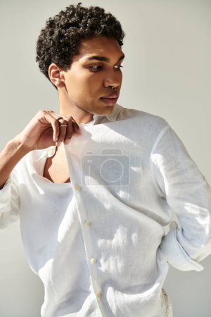 Foto de Modelo masculino afroamericano atractivo en ropa sofisticada de lino posando sobre fondo beige - Imagen libre de derechos