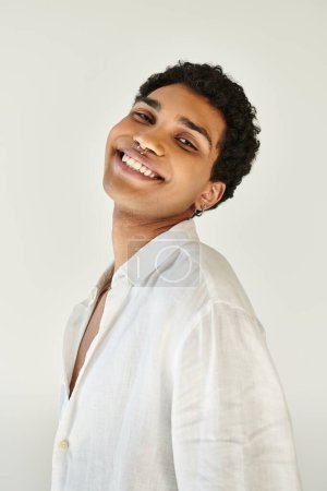 Foto de Alegre sofisticado afroamericano hombre en ropa de lino sonriendo a la cámara sobre fondo beige - Imagen libre de derechos