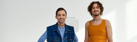 Photo for Joyous lgbtq friends in stylish outfits posing on gray backdrop and looking at camera, banner - Royalty Free Image