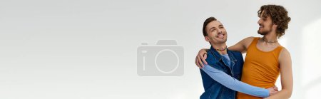 Photo for Good looking joyous lgbtq friends in vibrant clothes hugging on gray backdrop, pride month, banner - Royalty Free Image