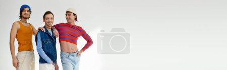 Photo for Jolly good looking lgbt friends in casual vibrant outfits posing actively on gray backdrop, banner - Royalty Free Image