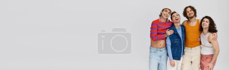 Téléchargez les photos : Joyeux attrayant gay les hommes dans vif costumes souriant à caméra tout en posant sur gris toile de fond, bannière - en image libre de droit