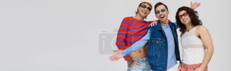 Photo for Three chic appealing gay friends in vibrant trendy attires with sunglasses, pride month, banner - Royalty Free Image
