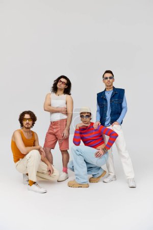 vier attraktive, fröhliche schwule Freunde mit stylischer Sonnenbrille posieren aktiv zusammen, stolzer Monat