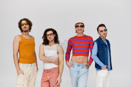 vier gut aussehende fröhliche schwule Freunde mit stylischer Sonnenbrille posieren aktiv zusammen, stolzer Monat