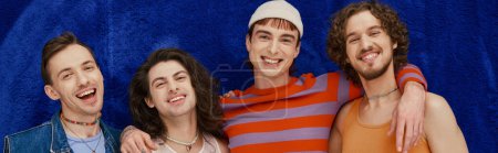 happy appealing stylish gay friends in everyday bright attires on blue backdrop, pride month, banner