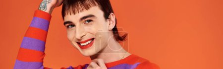 Photo for Jolly attractive stylish gay man with vibrant makeup in modish casual outfit, pride month, banner - Royalty Free Image