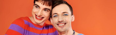 Photo for Jolly gay friends with vivid makeup posing together on orange backdrop, pride month, banner - Royalty Free Image