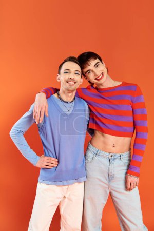 Photo for Joyful attractive gay friends with vivid makeup posing together on orange backdrop, pride month - Royalty Free Image