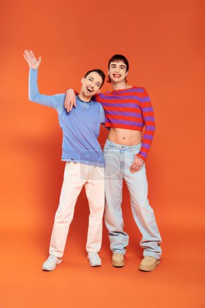 Photo for Joyous attractive gay friends with vivid makeup posing together on orange backdrop, pride month - Royalty Free Image