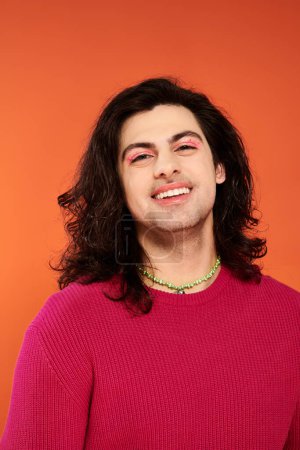 Photo for Joyous good looking gay man with long hair in magenta sweatshirt looking at camera, pride month - Royalty Free Image