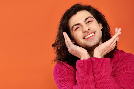 Photo for Joyful good looking gay man with long hair in magenta sweatshirt looking at camera, pride month - Royalty Free Image