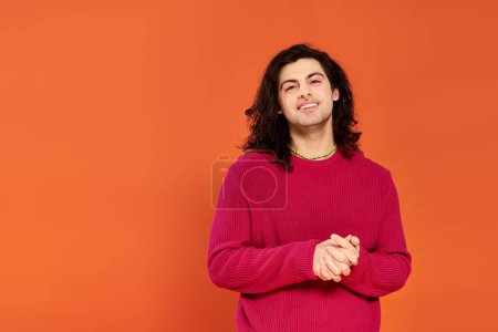 Foto de Alegre bien parecido gay hombre con largo cabello en magenta sudadera mirando a cámara, orgullo mes - Imagen libre de derechos