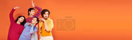 Photo for Cheerful gay men with makeup in vibrant attires posing actively together, pride month, banner - Royalty Free Image