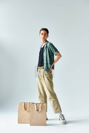 Un joven con estilo posa con confianza con bolsas de compras sobre un fondo blanco.