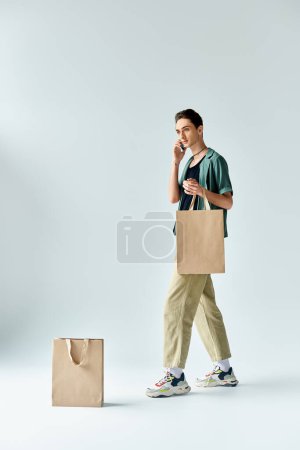 Une personne queer élégant se pavane en toute confiance avec des sacs à provisions sur un fond blanc.