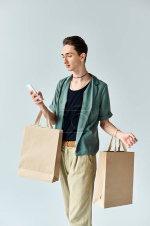 A young queer person holds shopping bags while looking at his phone, with a focused expression.