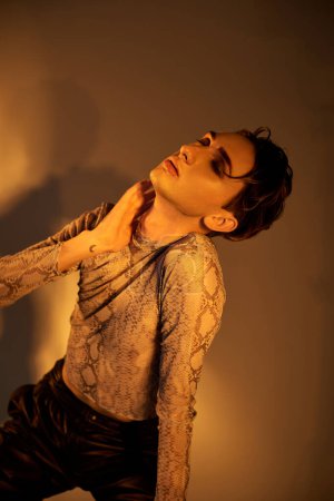 Foto de Una joven y elegante persona queer orgullosamente mostrando una serpiente enrollada alrededor de su pecho, exudando confianza y fuerza. - Imagen libre de derechos
