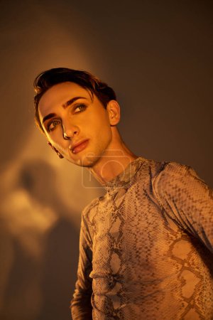 Photo for A young man exudes confidence in stylish attire, striking a pose against a dark background. - Royalty Free Image