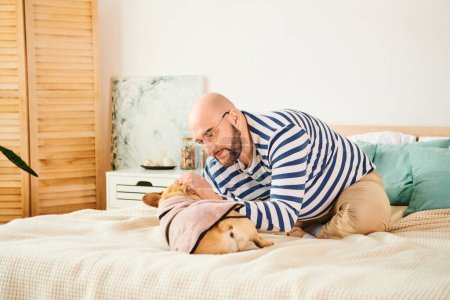 Photo for A man with glasses relaxing on a bed next to his French bulldog. - Royalty Free Image