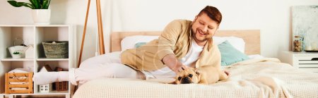 Photo for A man lounges alongside his French bulldog on a bed. - Royalty Free Image