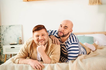 A couple of men enjoy a peaceful moment lounging on top of a bed.