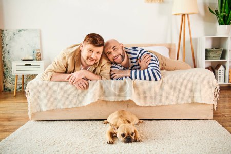 Two men, together with their French bulldog, relax on a bed in a cozy setting.