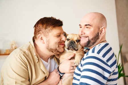 A man lovingly holds a small French Bulldog in his arms, sharing a sweet moment.