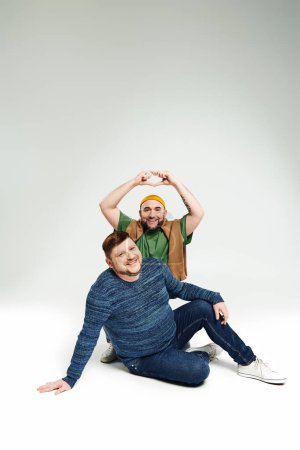 Deux hommes assis ensemble, posant pour une photo.