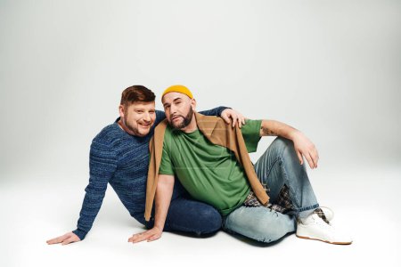 Photo for Two men sitting on the ground, posing for a picture. - Royalty Free Image