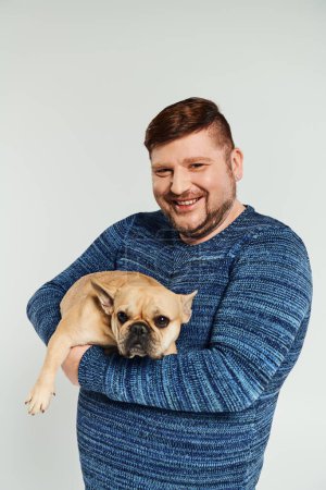 Foto de Un hombre tiernamente sostiene a un perro en sus brazos. - Imagen libre de derechos