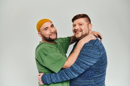 Foto de Dos hombres abrazándose amorosamente frente al fondo blanco. - Imagen libre de derechos