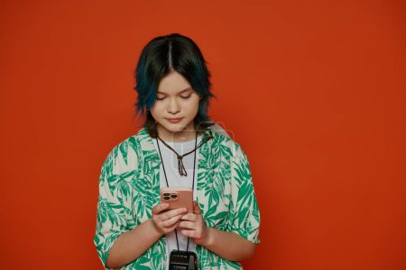 Une adolescente aux cheveux bleus vibrants regarde son téléphone portable dans un cadre de studio