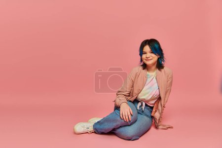 Photo for A girl with striking blue hair sits gracefully on the ground, exuding a serene aura of quiet confidence and individuality. - Royalty Free Image