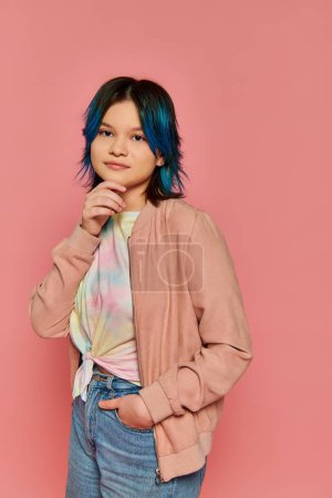 A girl with striking blue hair stands confidently in front of a vibrant pink wall, exuding creativity and individuality.