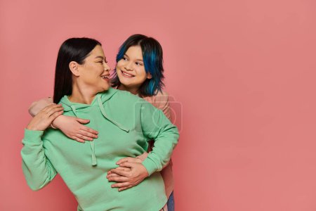 Téléchargez les photos : Un moment serein capturé en tant que mère asiatique et sa fille adolescente se tiennent élégamment côte à côte dans un cadre de studio. - en image libre de droit