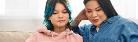 Téléchargez les photos : Asian mother and her teenage daughter with blue hair together at home. - en image libre de droit