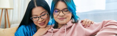 Asian mother and her teenage daughter with blue hair bonding at home