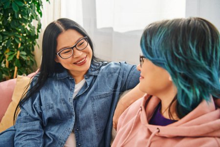 Photo for Asian mother and teenage daughter engage in heartfelt conversation on a cozy couch at home, creating a warm and loving atmosphere. - Royalty Free Image