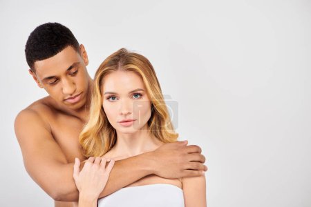 Photo for Man and woman share an intimate hug on a white background. - Royalty Free Image