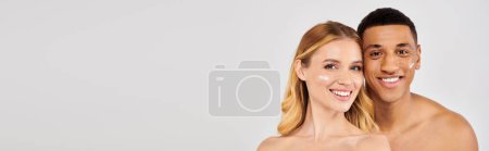 Téléchargez les photos : Un homme et une femme souriant devant un fond blanc, crème sur le visage. - en image libre de droit