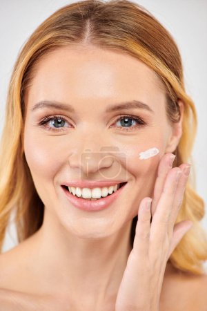 Smiling woman enjoying facial cream application.