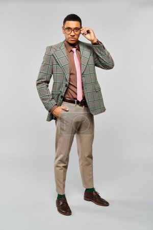Foto de Stylish man posing confidently in a fashionable green blazer and a pink tie. - Imagen libre de derechos