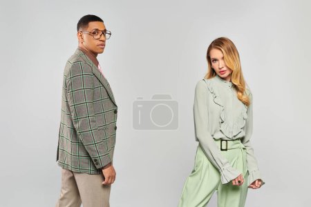 Foto de Pareja de moda en pantalones verdes y blazers de pie juntos. - Imagen libre de derechos