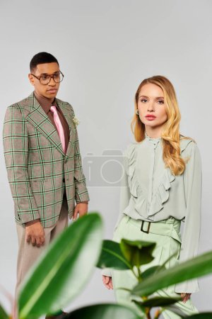 Photo for Man and woman pose gracefully in front of plant. - Royalty Free Image