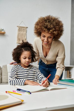 Afroamerikanische Mutter und Tochter engagieren sich zu Hause intensiv für Hausaufgaben und fördern durch gemeinsames Lernen eine starke Bindung.