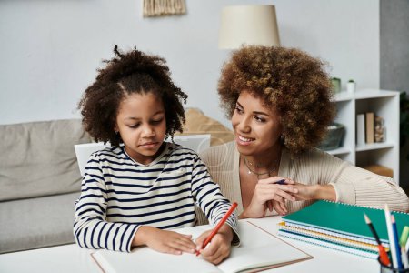 African American mother and daughter engaged in academic activities together at home.
