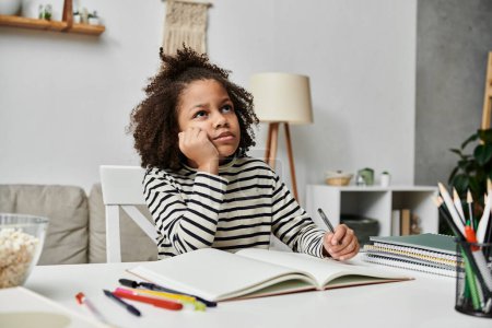 Foto de Una niña absorta en un libro abierto mientras está sentada en una mesa, explorando las maravillas de la literatura - Imagen libre de derechos